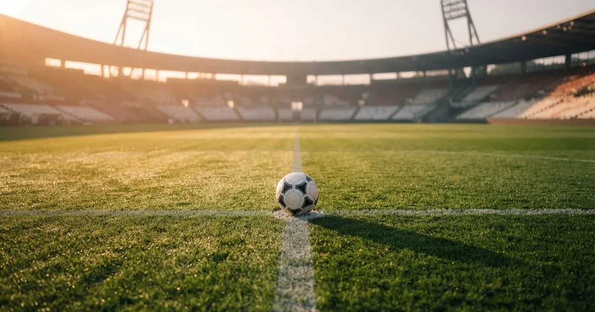 Un balón en el punto central de un campo de césped a la luz de la mañana
