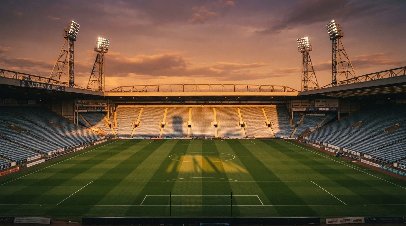 Un estadio de fútbol vacío con torres de iluminación al atardecer